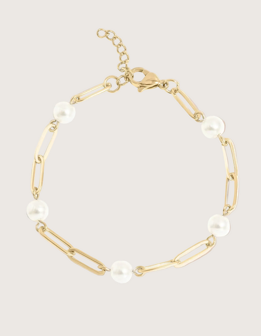 Gold paperclip chain bracelet with pearls on an ivory background